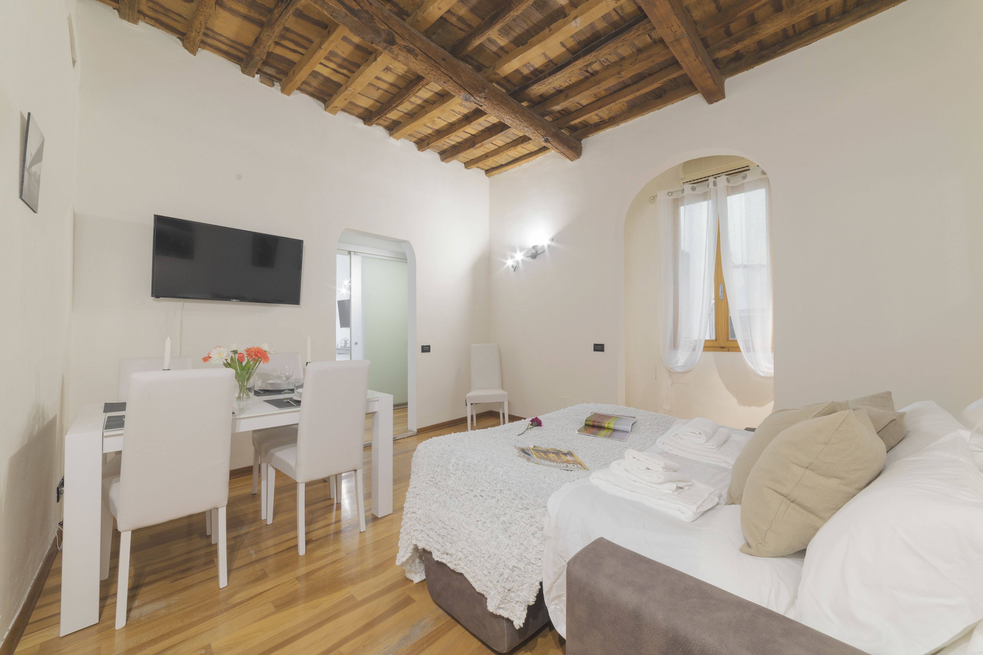 Ein Schlafzimmer mit Bett, Schreibtisch, Stuhl und Fernseher.