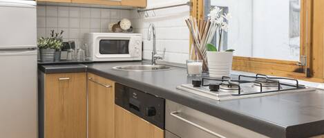 A modern kitchen with wooden cabinets, a microwave, a sink, and a stove.