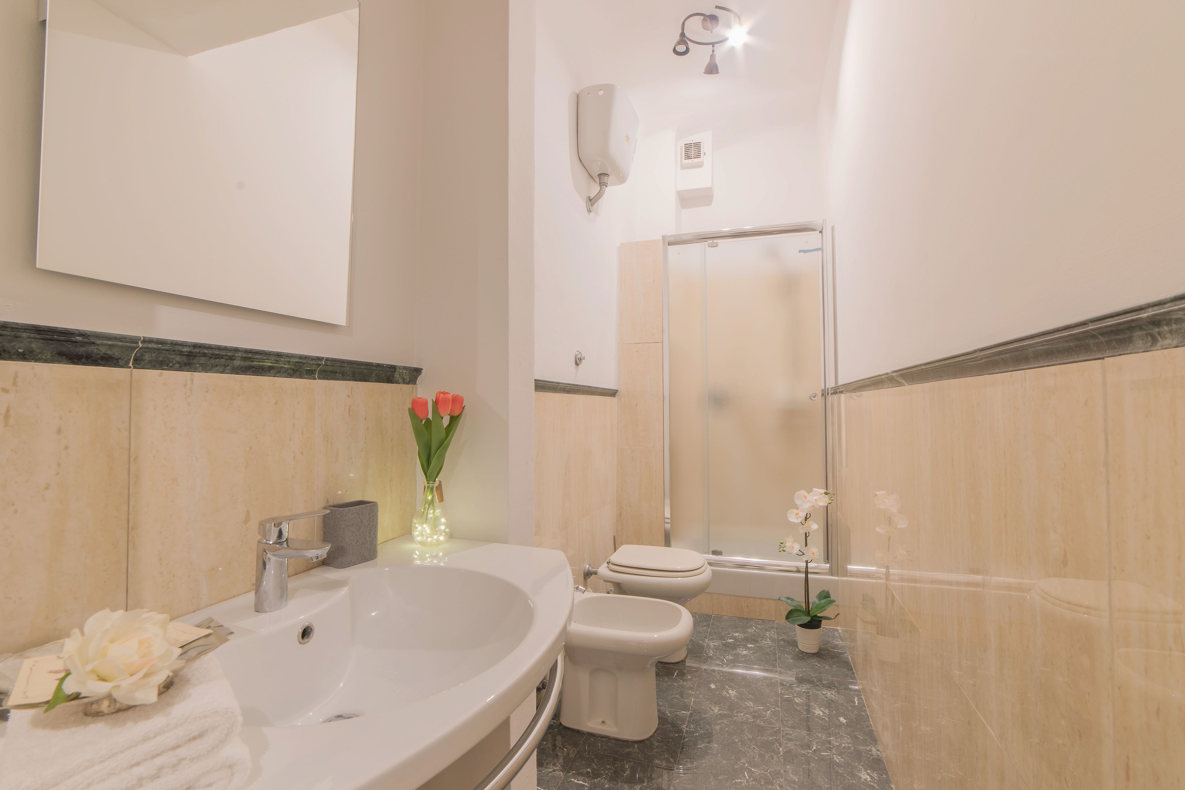 Ein Badezimmer mit Waschbecken, Toilette und Duschbereich.
