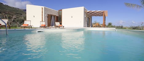 Piscine extérieure, parasols de plage, chaises longues