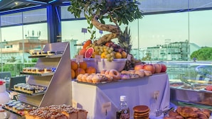 A buffet with a variety of pastries, fruits, and a decorative tree. - Monaco Suites Hotel (Lignano Sabbiadoro)