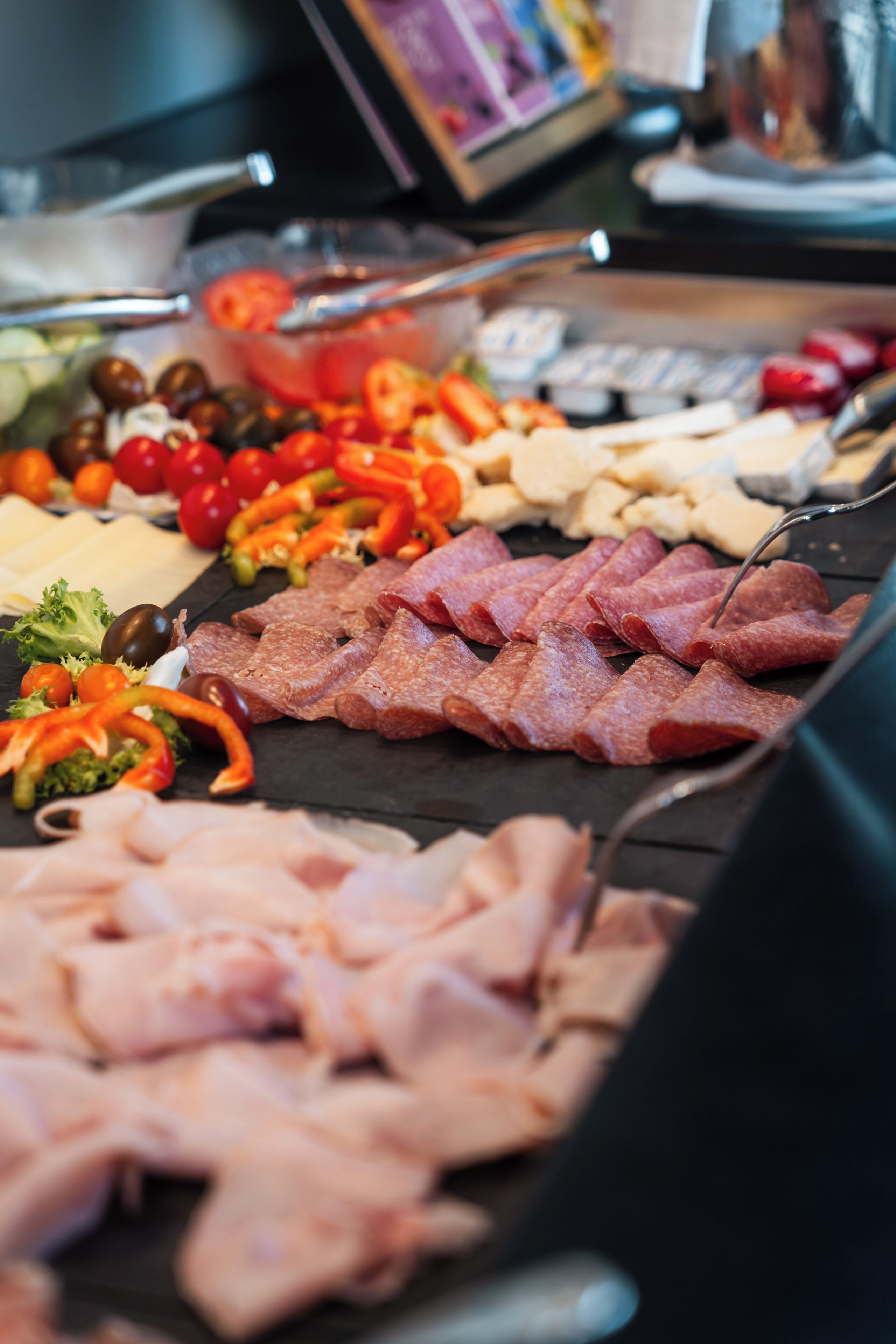 Un buffet proposant une variété de viandes, de fromages et de légumes.