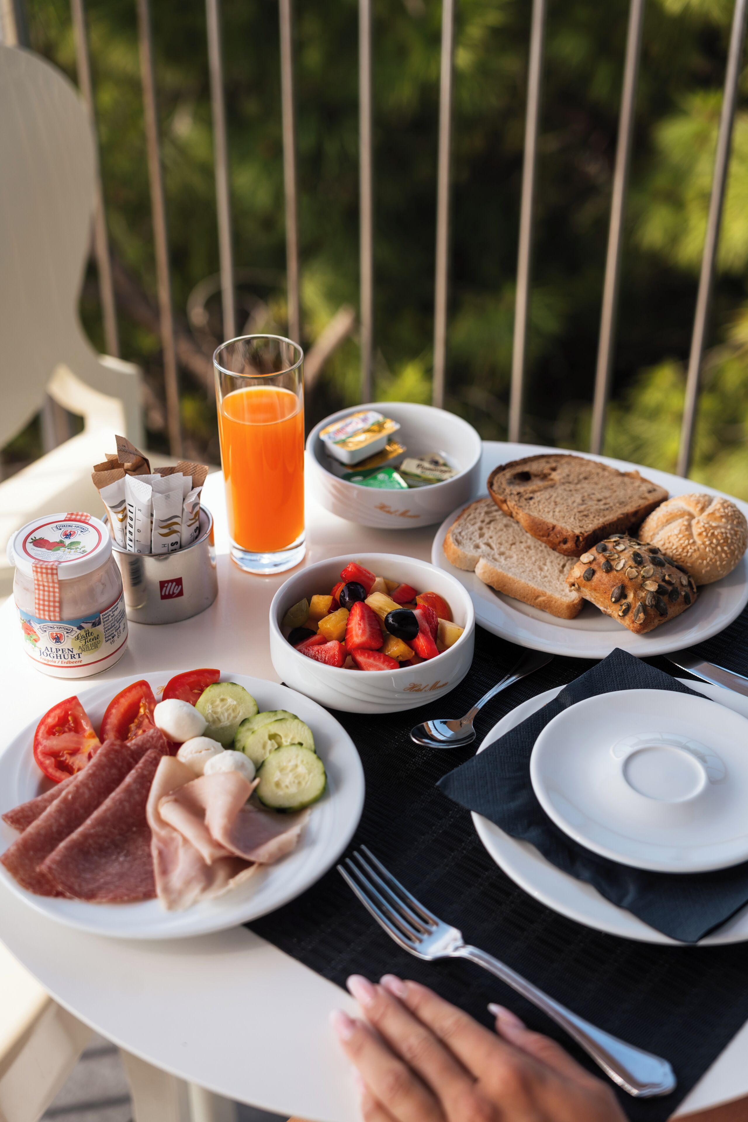 A table with breakfast items including bread, fruit, and a glass of orange juice.
