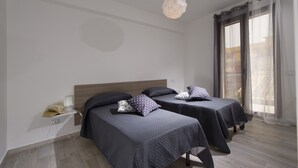 A modern bedroom with two beds, a bedside table with a lamp, and a large window with curtains. - La Suite Di Tyche (Castellammare del Golfo)