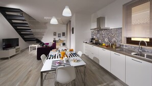 A modern kitchen with a dining area, a staircase, and a living room. - La Suite Di Tyche (Castellammare del Golfo)