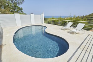 Piscine extérieure, parasols de plage, chaises longues