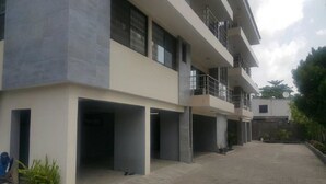 A multi-story building with a flat roof, large windows, and a covered parking area. - Gemini Place Apartments (Lagos)