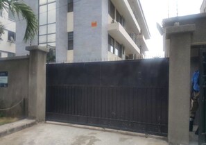 Una entrada cerrada con un pilar de hormigón y una verja metálica.