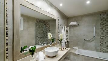 Un baño moderno con un espejo grande, un lavabo redondo, una bañera y una zona de ducha.