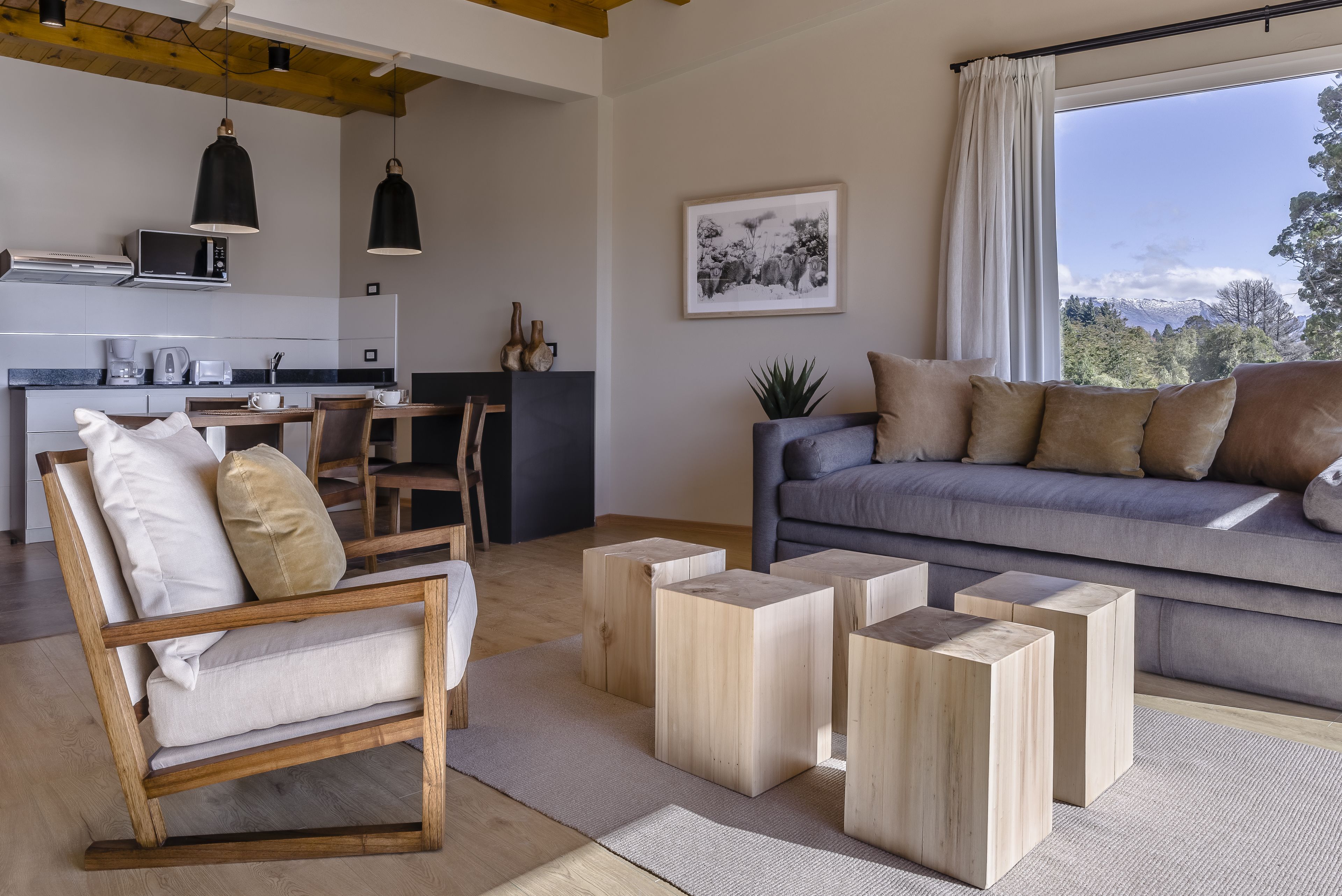 A modern living room with a sofa, wooden coffee table, and a dining area with a table and chairs.