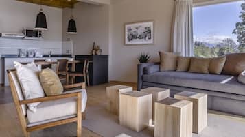 Una sala de estar moderna con un sofá, una mesa de centro de madera y un comedor con mesa y sillas.