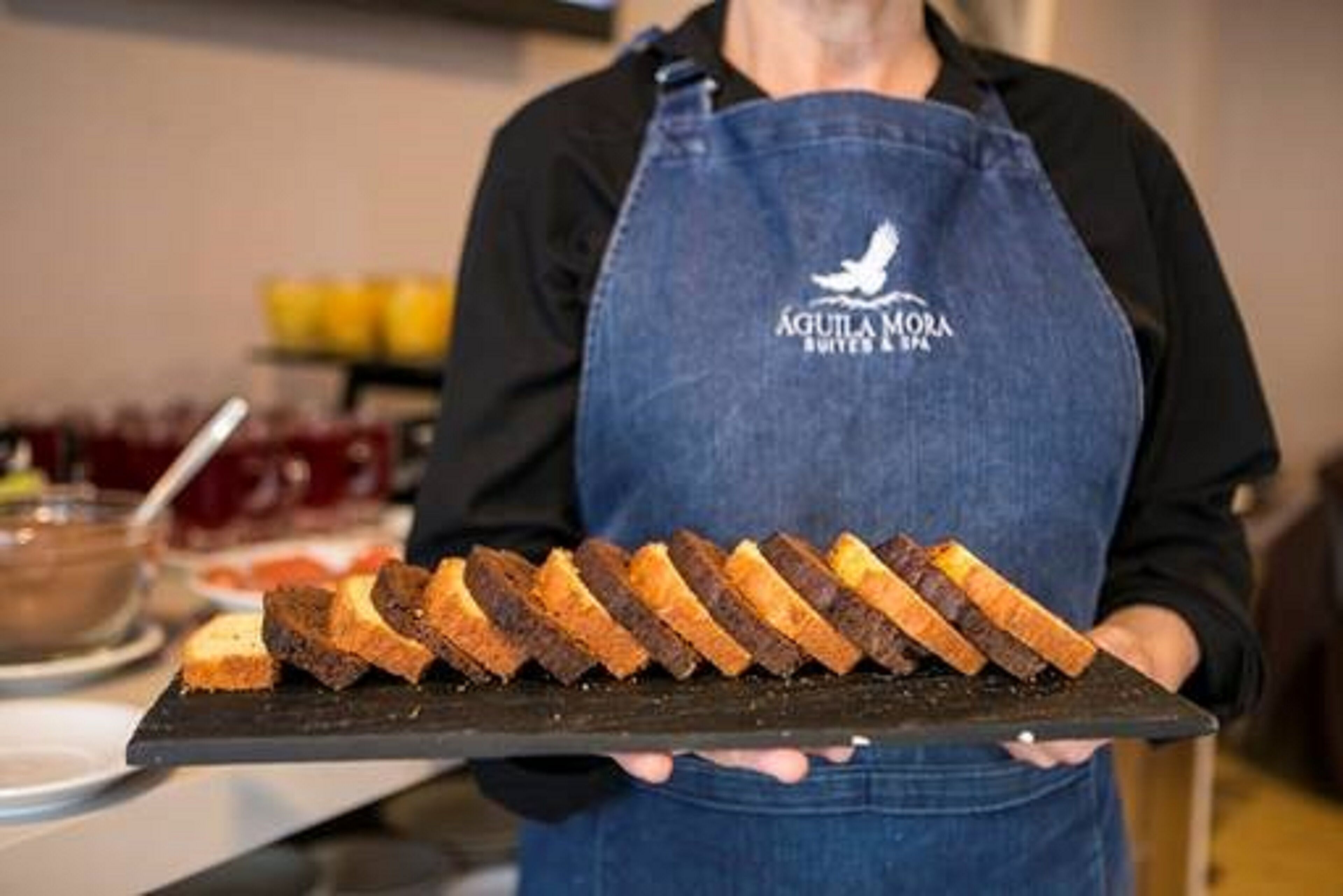 Een persoon die een dienblad met sneetjes brood vasthoudt.
