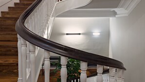 A curved staircase with white balusters and a dark handrail, leading to an upper floor. - B The Guest Downtown (Porto)