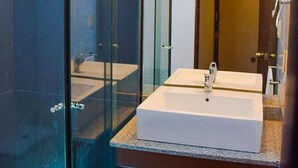 A modern bathroom with a glass-enclosed shower, a white sink, and a mirror above it. - HB Sopocachi (La Paz)
