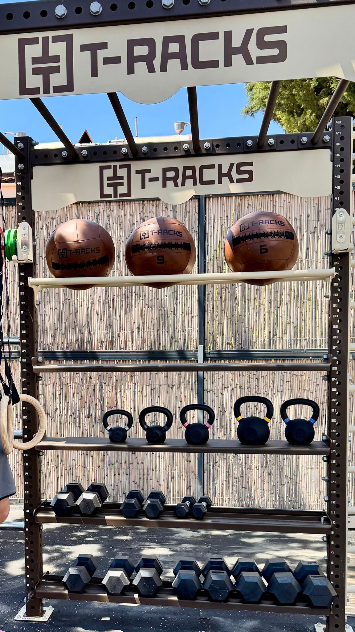 Een T-Racks fitnessapparaat voor krachttraining, met halters, kettlebells en dumbbells.