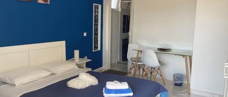 A bedroom with a bed, a desk, and a chair.