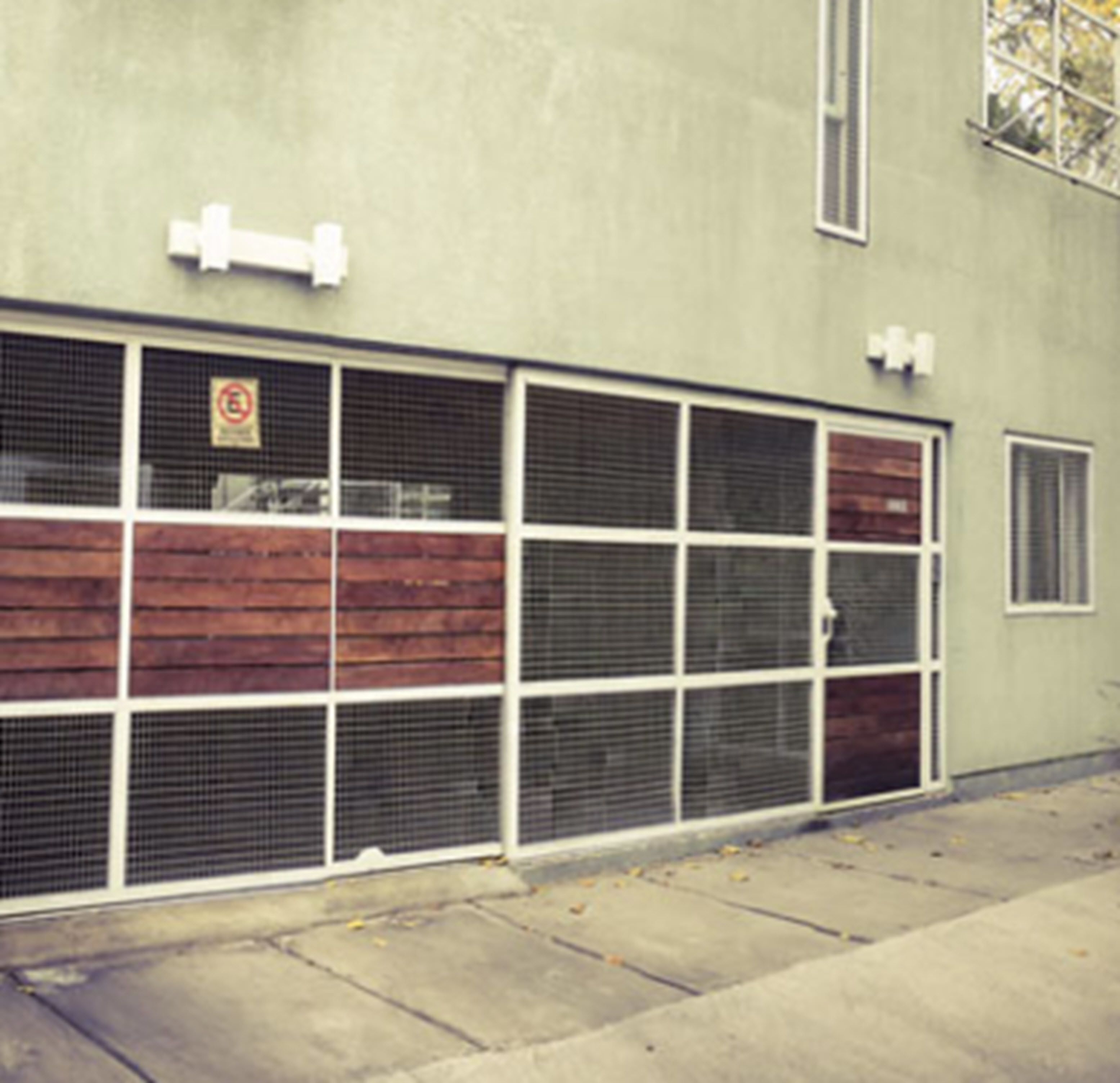 Un bâtiment doté d’une porte de garage, d’une fenêtre avec une enseigne et d’une petite fenêtre sur la droite.