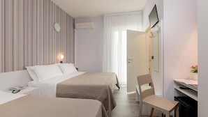 A hotel room with two beds, a desk, a chair, a TV, and a mirror. - Hotel Ervill (Rimini)