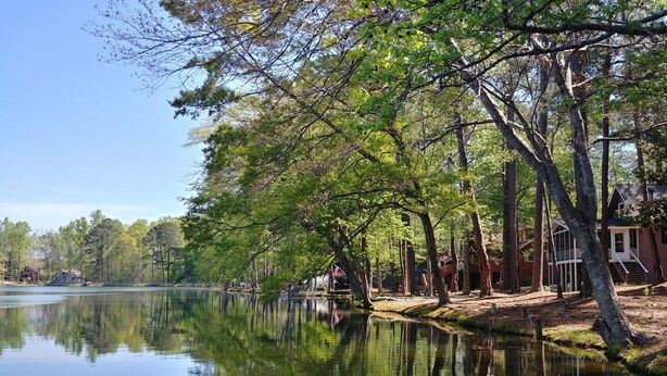 A serene lakeside setting with a wooden cabin and a clear view of the water. - Pine Mountain Club Chalets Resort (Pine Mountain)