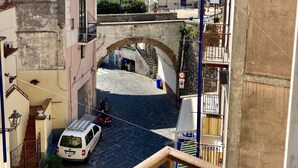 A narrow street with a stone bridge, buildings with balconies, and a white van parked on the side. - La Corte Dei Naviganti B&B - Amalfi Coast - Cetara (Cetara)