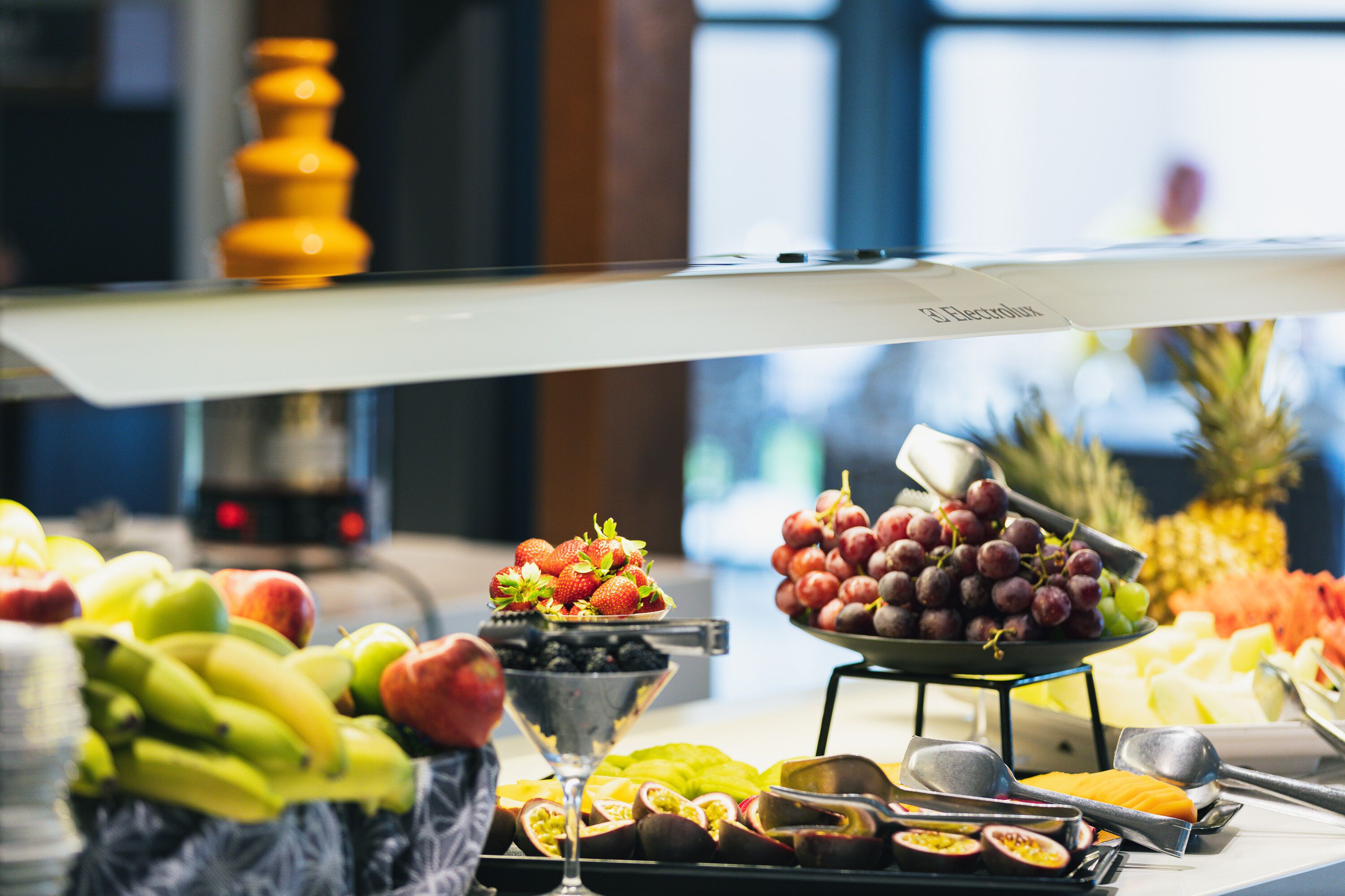 A buffet with various fruits and vegetables, including bananas, apples, and grapes.