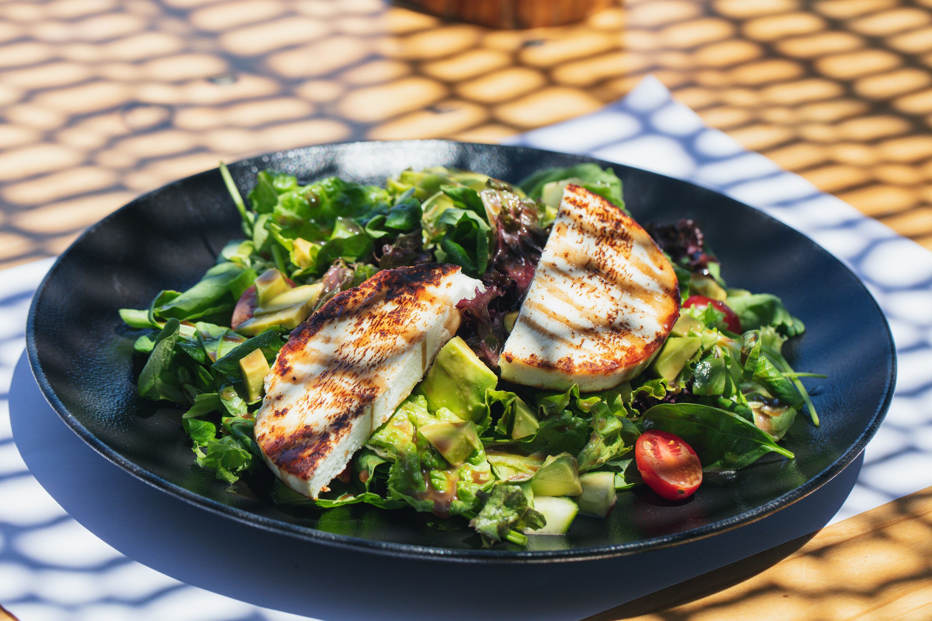 Une assiette de poulet grillé et de salade sur une table.
