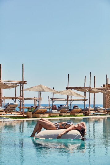 Een privéstrand, ligstoelen aan het strand, parasols, strandlakens