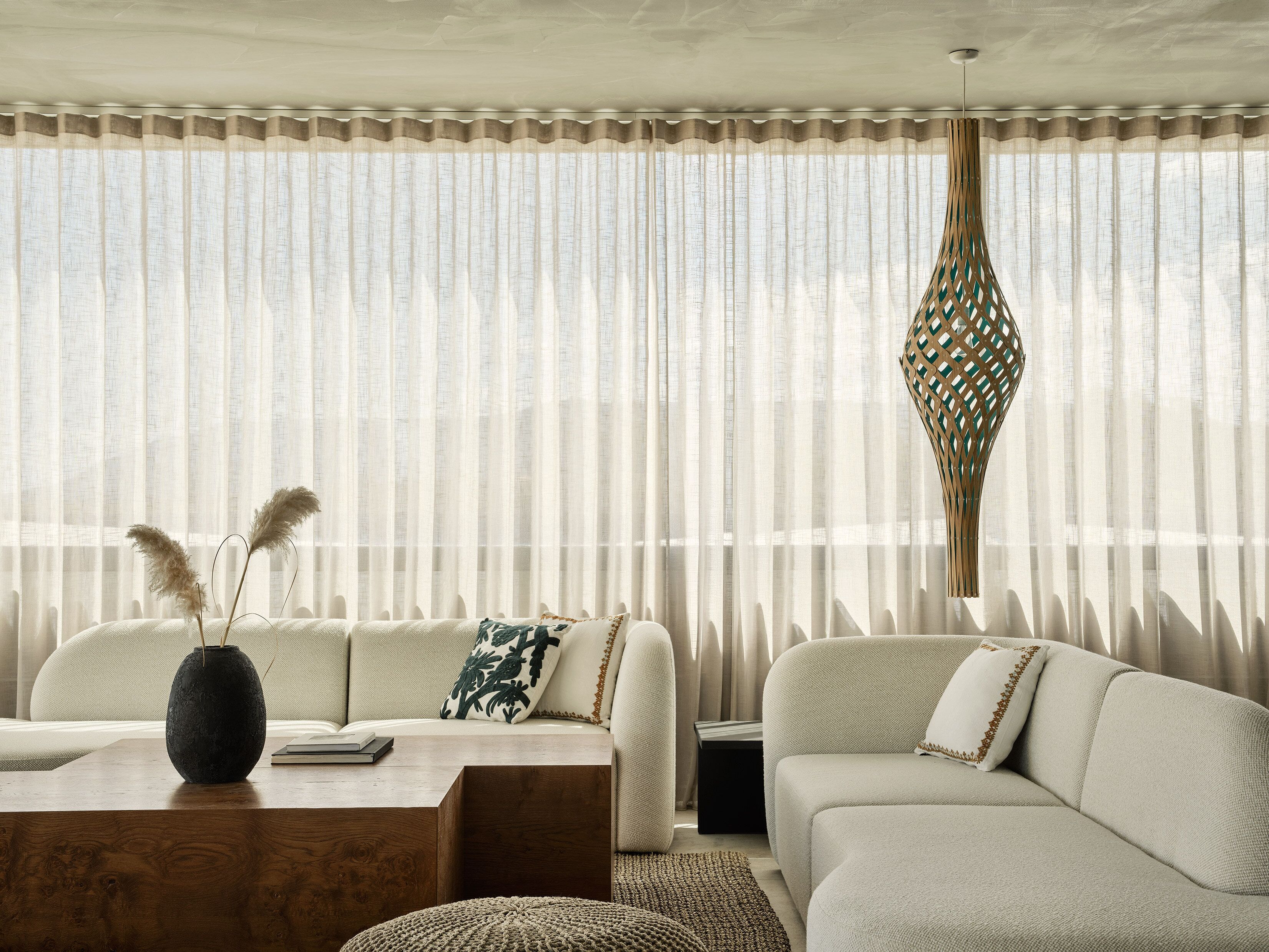 A modern living room with a sofa, a wooden coffee table, and a decorative vase.