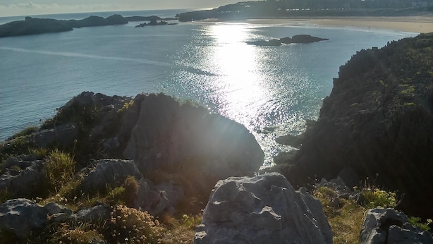 A coastal landscape with rocky outcrops and a calm sea. - Hostal Isla Playa (Arnuero)