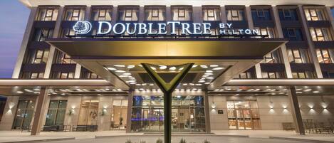A hotel entrance with a prominent sign reading "DOUBLETREE BY HILTON".