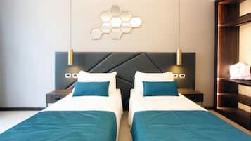 A hotel room with two beds, a modern headboard, a wall-mounted hexagonal light fixture, and bedside tables with lamps.