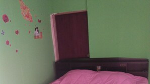 Um quarto com uma cama, uma cômoda e uma porta.