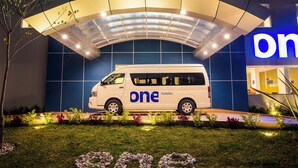A white van with "one hotels" branding parked in front of a building with a blue and white color scheme. - One Ciudad de Mexico La Raza (Mexico City)