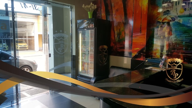 Ein Hotel-Rezeptionsbereich mit Glastür, einer Minibar und einem farbenfrohen Wandgemälde.