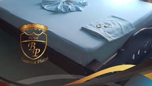 Ein Hotelzimmer mit Bett, einem Vorhangfenster, einer Klimaanlage und dem Logo von Bucarica Plaza.