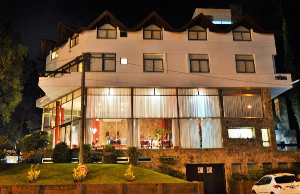 A multi-story hotel with a modern design, featuring large windows and a stone facade.