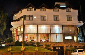 A multi-story hotel with a modern design, featuring large windows and a stone facade. - Hotel Piedras Doradas (Valeria del Mar)