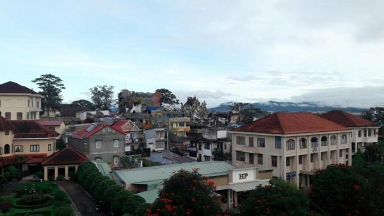 A residential area with various buildings, including a large white building with "HP" on it, surrounded by smaller houses and greenery.