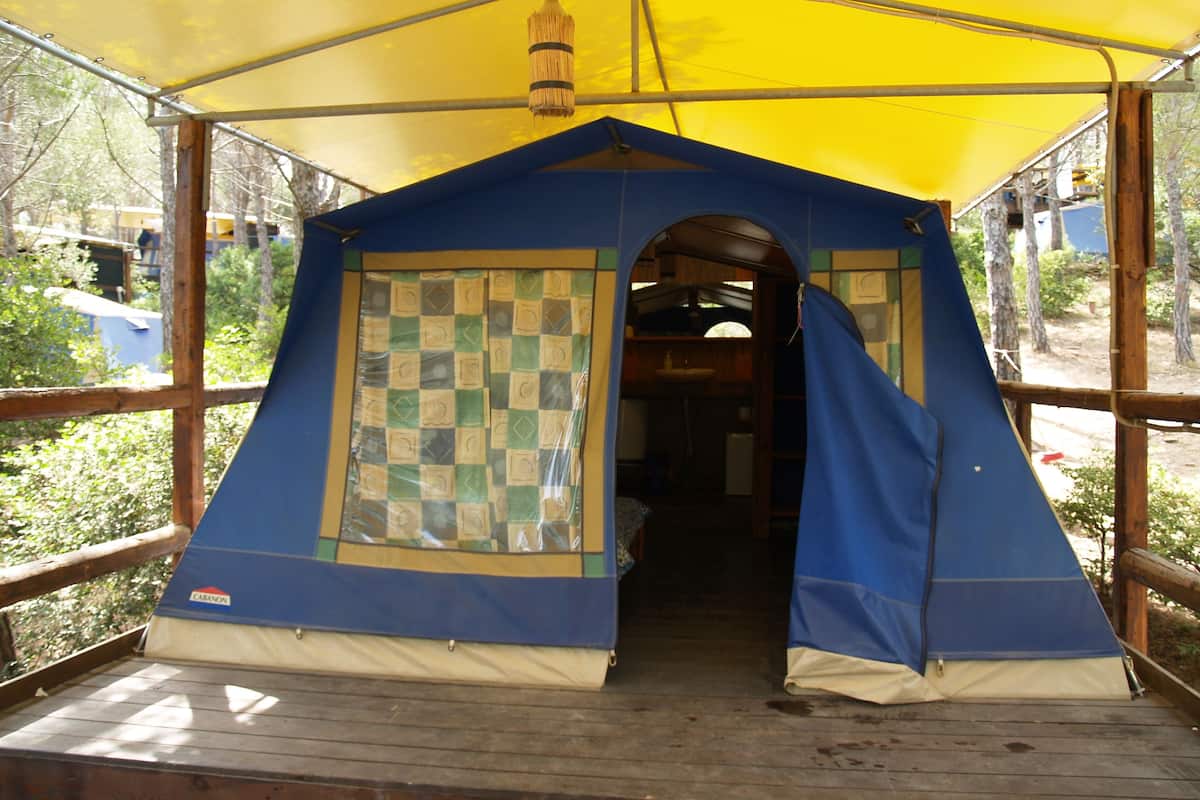 A blue tent with a checkered pattern on one side, a wooden deck, and a yellow canopy overhead.