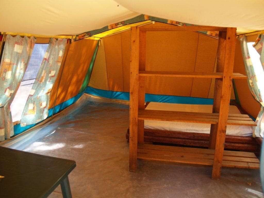 A tent with a wooden ladder and a table.