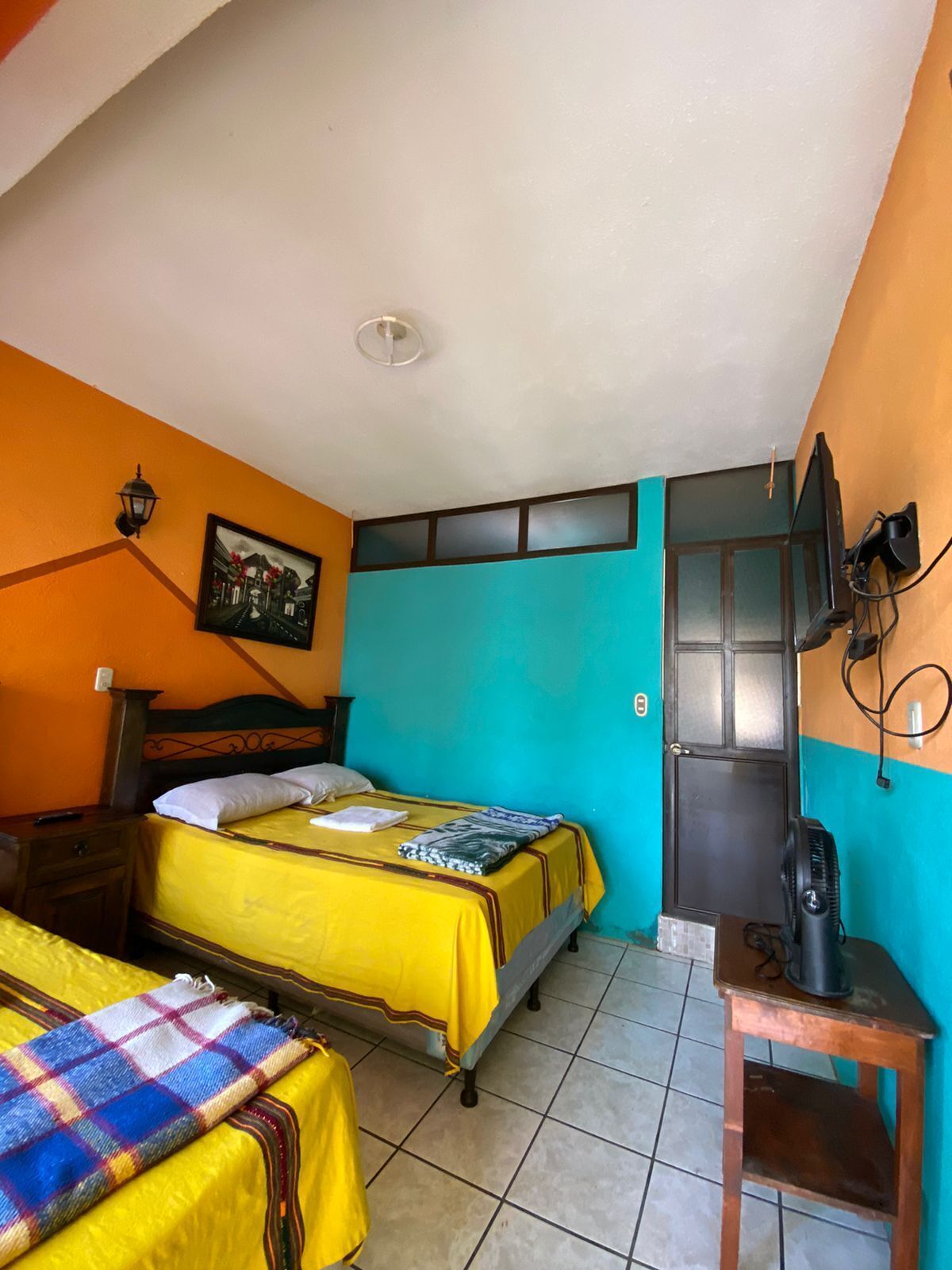 A room with two beds, a television, and a door.