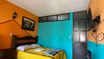 A room with two beds, a television, and a door.