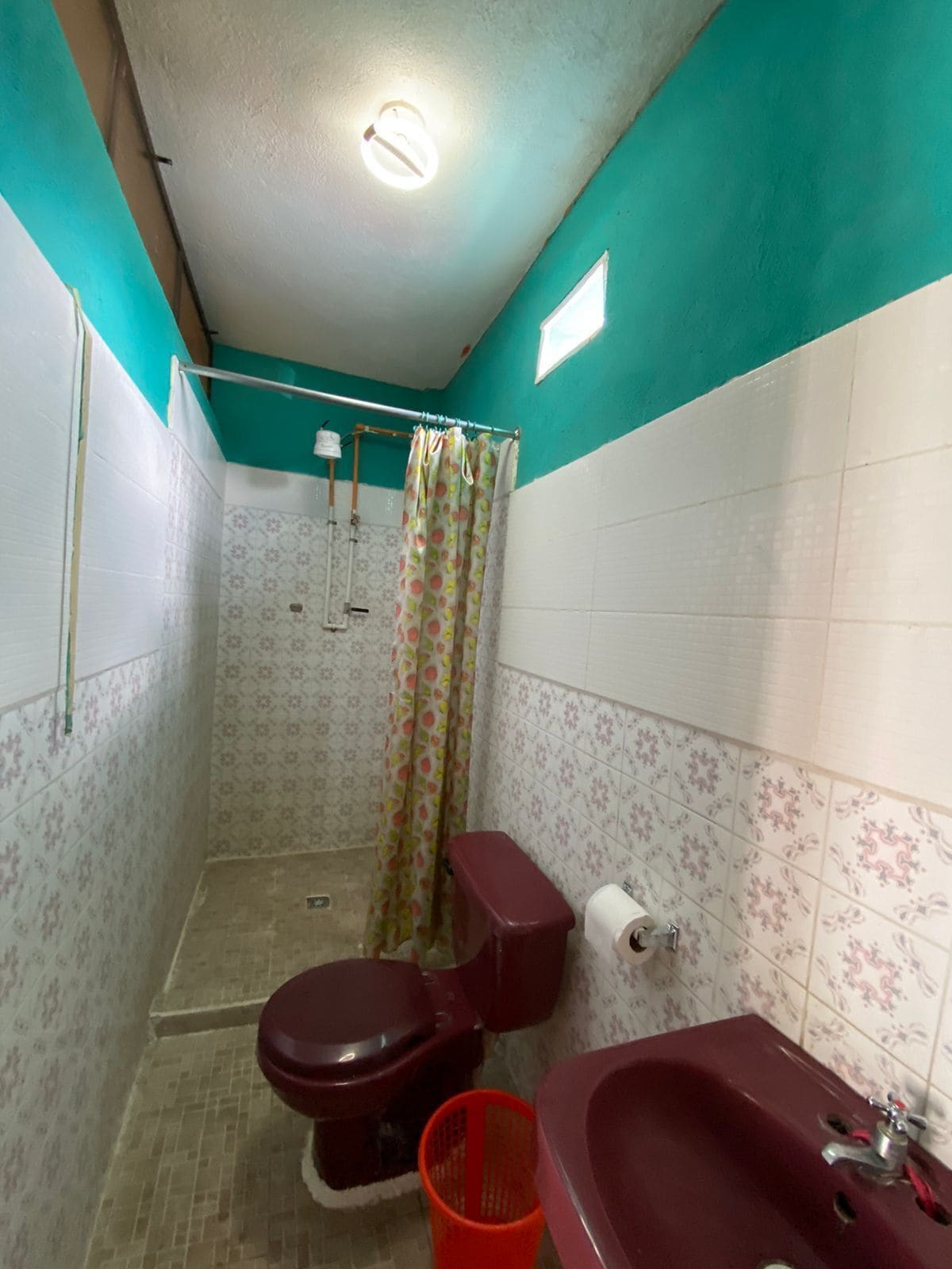 Un baño pequeño con inodoro, lavamanos y cortina de ducha.
