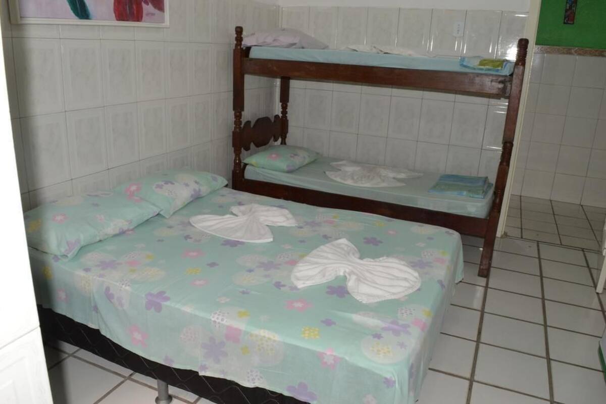 Ein Stockbett mit Blumenmuster-Bettwäsche und einem hölzernen Kopfteil.