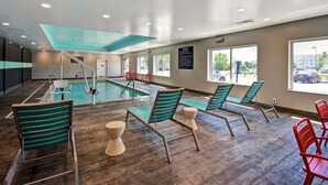 An indoor swimming pool area with lounge chairs and a view of the parking lot. - Tru by Hilton Fort Wayne, IN (Fort Wayne)