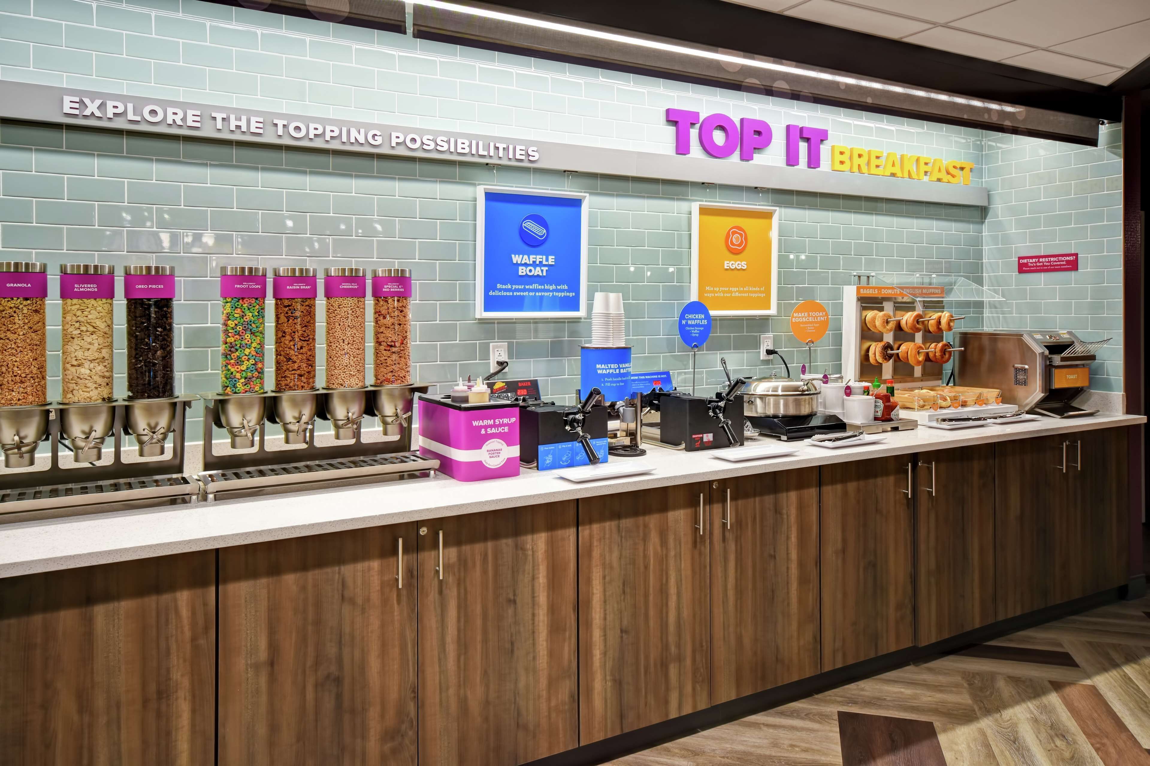 A breakfast buffet with various toppings and a waffle boat station.
