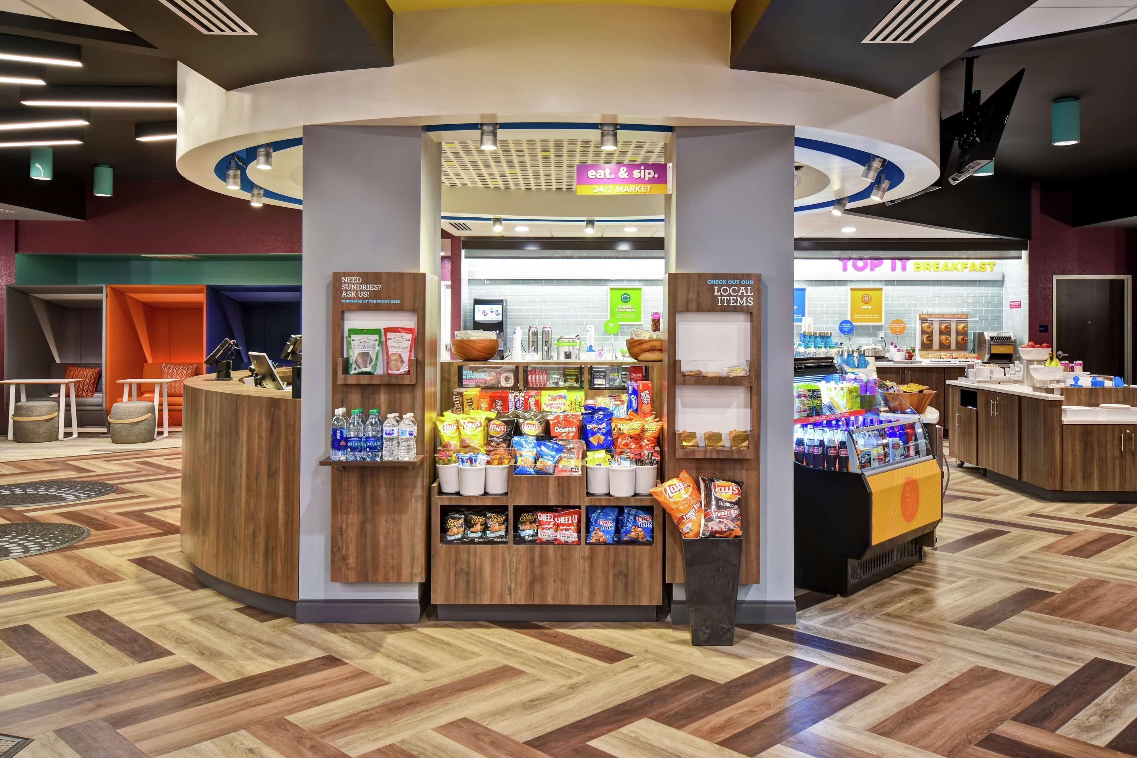 A 24/7 market area with snack and drink options, a breakfast counter, and a reception desk.