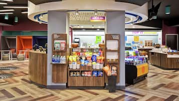 A 24/7 market area with snack and drink options, a breakfast counter, and a reception desk.