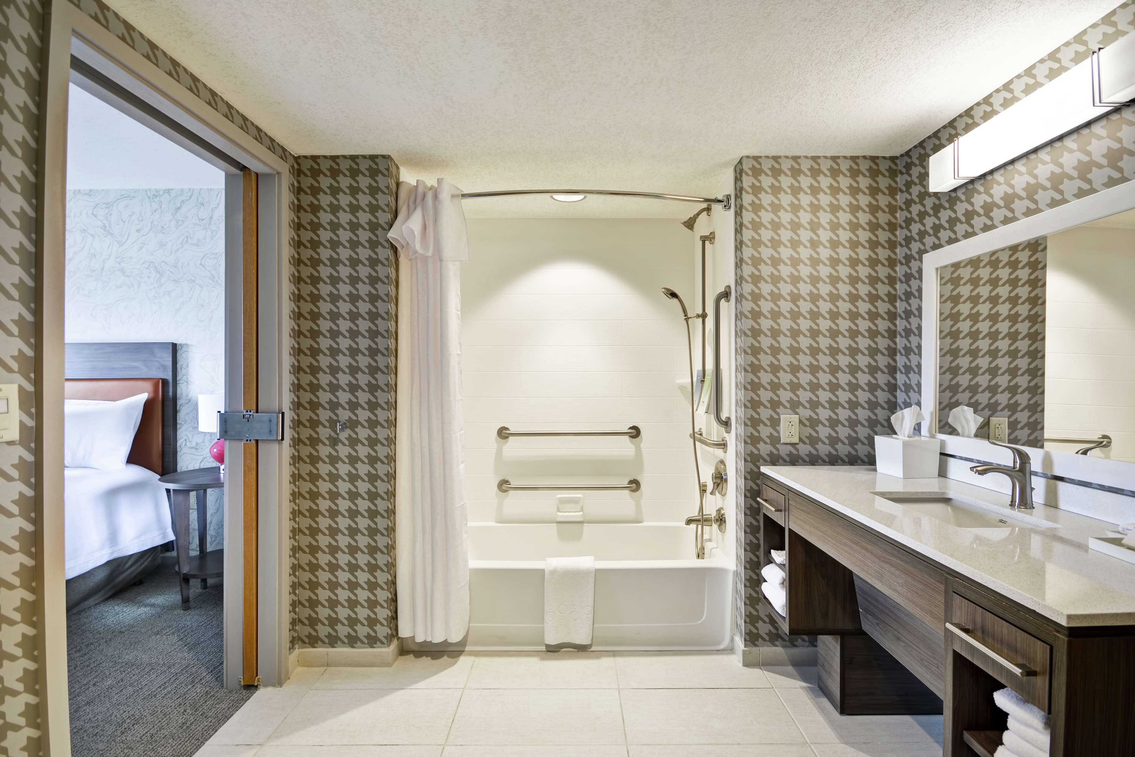A modern bathroom with a bathtub, shower, and vanity.