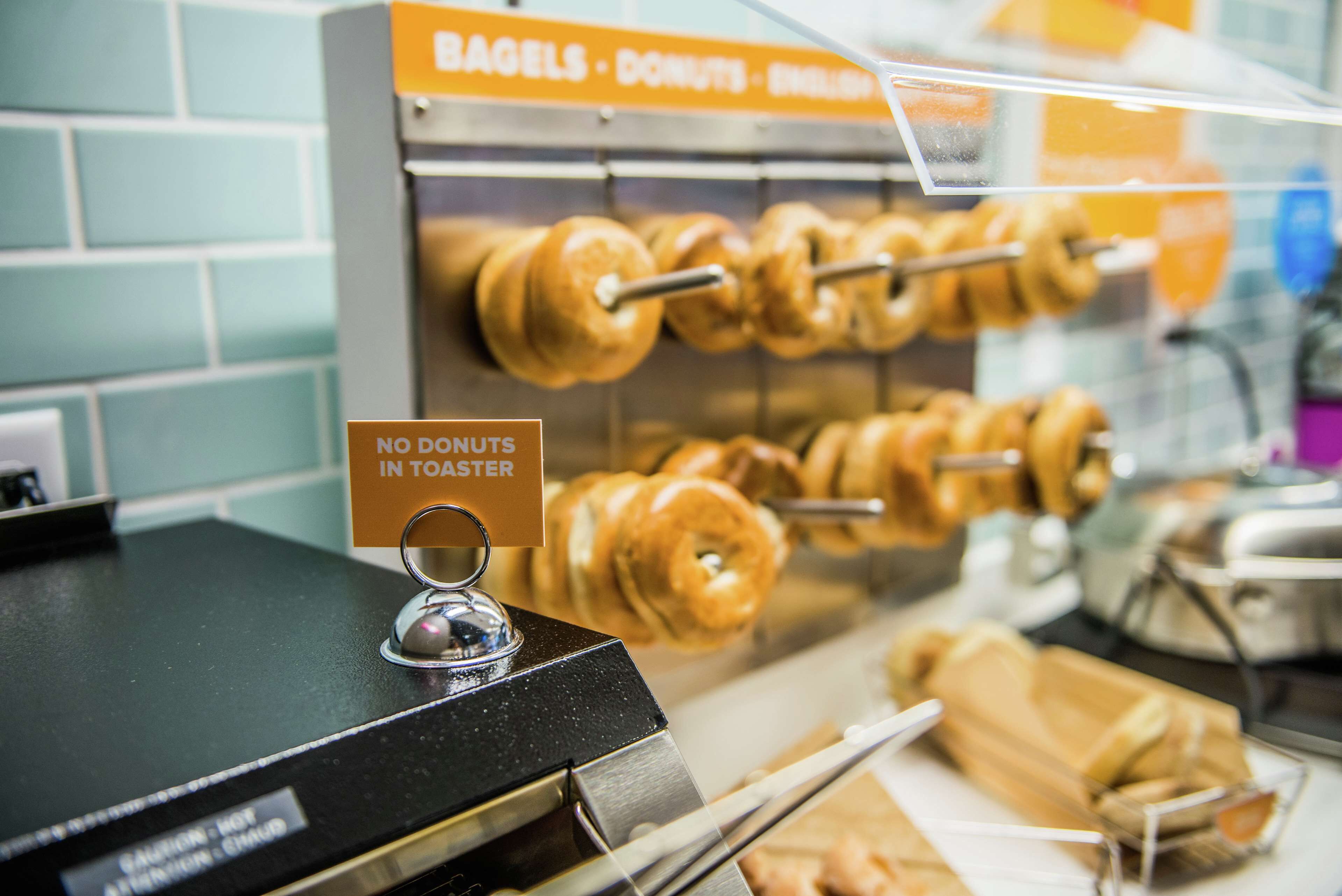 Una vitrina de donas con un letrero que indica que no hay donas calientes.
